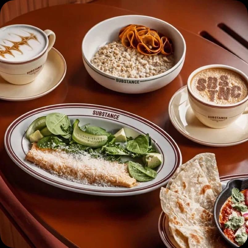 Сервировка бранча Substance: салат с авокадо, каша с чипсами, два капучино и лепёшка с соусом