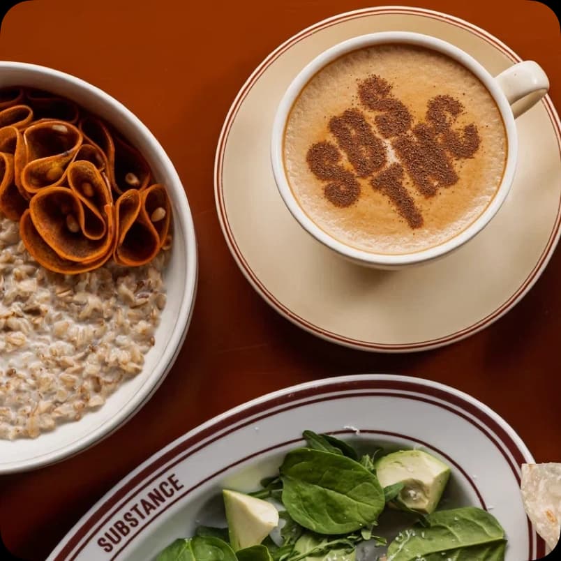 Капучино с лого SBNC и каша с чипсами рядом с салатом