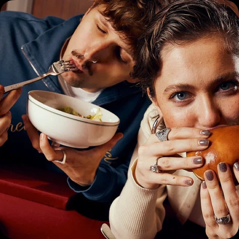 Пара ест суп и бургер крупным планом