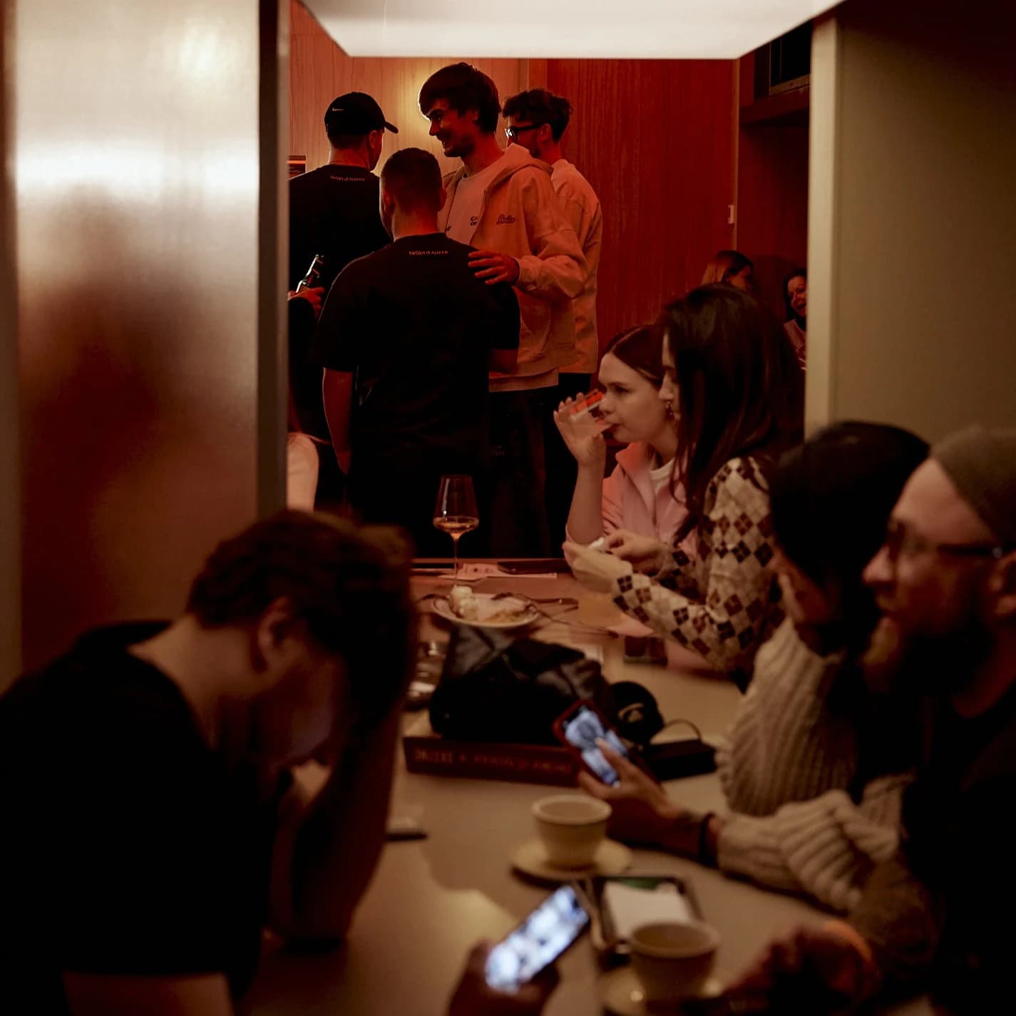 Вечерняя атмосфера Substance: компания гостей за столом в тёплом свете